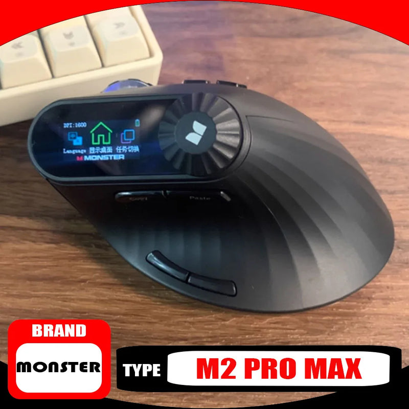 Black computer mouse with digital display on a wooden surface, featuring the Monster M2 Pro Max model.